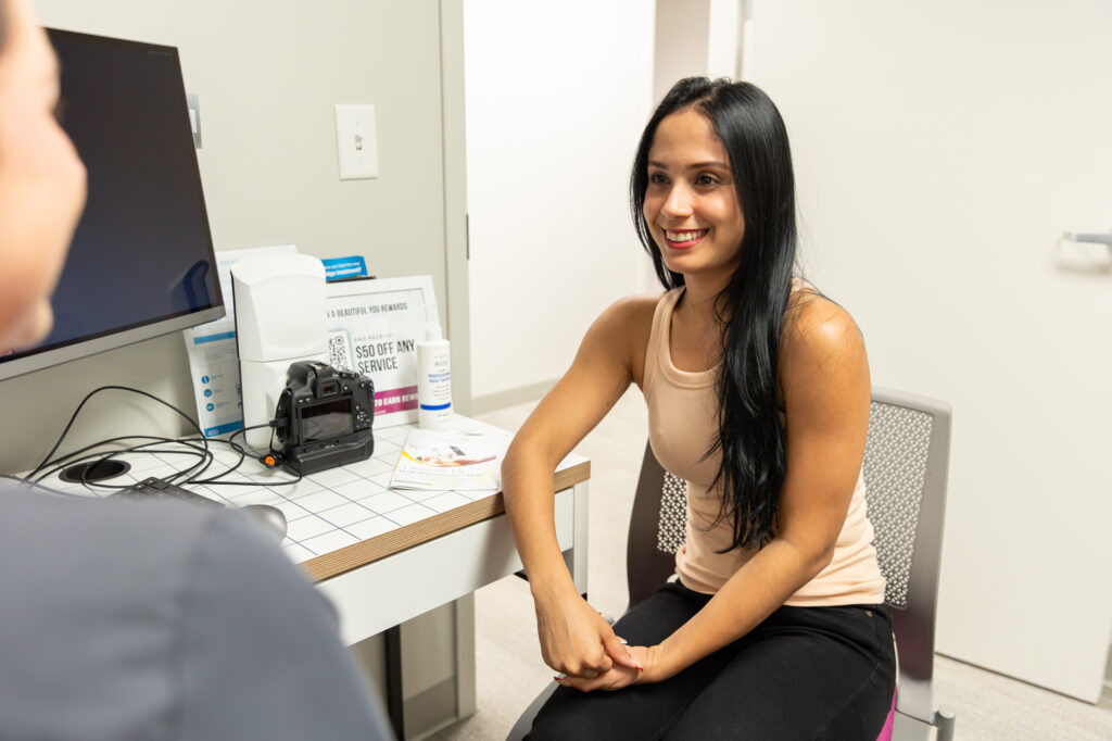 A woman smiles at her Emsella provider before pelvic floor therapy in Memphis